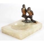 A COLD PAINTED BRONZE GROUP OF KINGFISHERS PERCHED ON A LOG AND SET ON AN ONYX ASHTRAY, 13CM L,