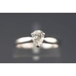 A white metal single stone ring set with a pear brilliant cut diamond.