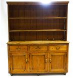 A Victorian pine dresser with two shelf plain plank back under a plain cornice,