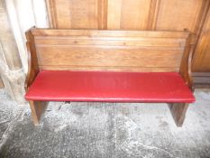 A oak pew with single panelled back and prayer book shelf to the reverse,134cm wide, 40cm deep,