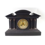 A black stone Temple style mantel clock with four brass topped corinthian columns