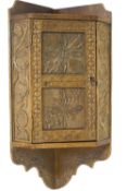 A small carved oak wall hanging cupboard with high relief floral and foliate decoration,