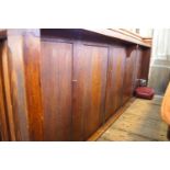 A Victorian pine pew with triple paneled back and prayer book shelf to reverse with one wall end