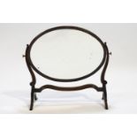An Edwardian mahogany oval swing frame mirror,