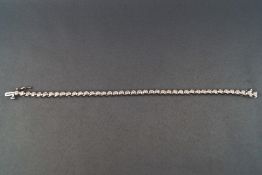 A modern white metal diamond line bracelet.