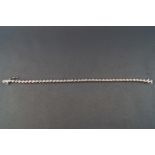 A modern white metal diamond line bracelet.