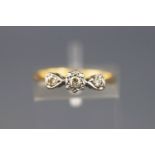 A yellow and white metal three stone diamond ring, approx 0.10cts. Stamped 18ct. Size: J 1/2, 2.
