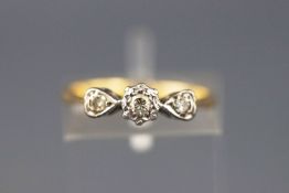 A yellow and white metal three stone diamond ring, approx 0.10cts. Stamped 18ct. Size: J 1/2, 2.