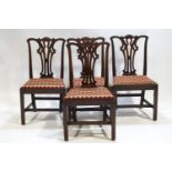 A set of four Georgian mahogany dining chairs with shaped crest rails
