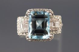 A modern white metal dress ring set with a rectangular aquamarine