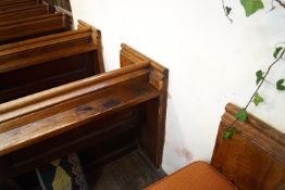A Victorian pine pew with triple paneled back and prayer book shelf to reverse with one wall end