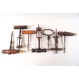 A collection of seven corkscrews, including two with brushes,