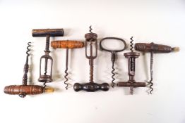 A collection of seven corkscrews, including two with brushes,