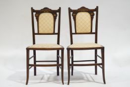 A pair of Edwardian mahogany salon chairs with inlaid decoration to the padded backs
