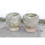 A pair of composite stone garden urns with Greek key fret borders, 38cm high,