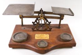 A set of oak and brass inlaid letter and parcel scales, set with three weights to the base,
