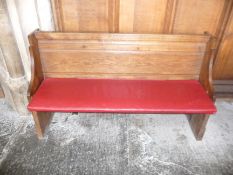A oak pew with single panelled back and prayer book shelf to the reverse, 134cm wide, 40cm deep,