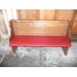 A oak pew with single panelled back and prayer book shelf to the reverse, 134cm wide, 40cm deep,