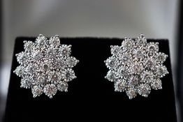 A modern white metal pair of diamond cluster stud earrings.