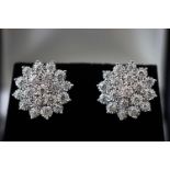 A modern white metal pair of diamond cluster stud earrings.