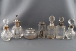 A cut glass scent bottle with silver collar and six other dressing accessories