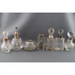 A cut glass scent bottle with silver collar and six other dressing accessories