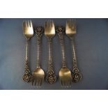 Five gilt cake forks, with double struck open contrived foliate handles,