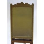 A heavy carved wood framed wall mirror with bevelled plate with arts and crafts style carved top