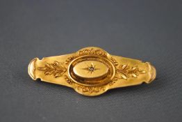 A yellow metal Victorian hollow bar brooch having a scroll finish and set with a rose cut diamond.