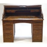 An oak roll top desk with eight drawers flanking a central drawer,
