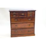 A mixed hardwood Scottish style chest of drawers with a central deep drawer