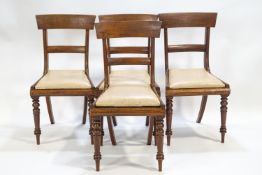 Four Regency mahogany dining chairs of plain form with splat backs and tip in seats
