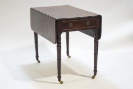 A mahogany Pembroke table of usual form, raised on turned legs on brass castors,