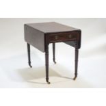 A mahogany Pembroke table of usual form, raised on turned legs on brass castors,