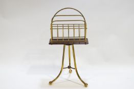 A mahogany and brass double section magazine rack raised on a tripod base,