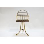 A mahogany and brass double section magazine rack raised on a tripod base,