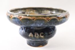 A Doulton low bowl of contrived, intertwined form decorated in blues and greens,