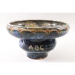 A Doulton low bowl of contrived, intertwined form decorated in blues and greens,