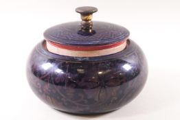 A Bernard Moore tobacco jar, decorated with a flambe floral motif,