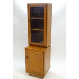 An Ercol elm wood standing cabinet of rounded rectangular form,