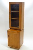 An Ercol elm wood standing cabinet of rounded rectangular form,