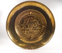 A brass alms dish, embossed to the centre with the grape carriers,