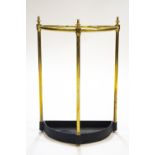 A brass framed umbrella stand of semi-circular form with a cast metal drip tray,