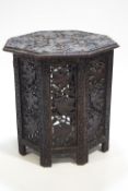 A Middle Eastern hardwood octagonal table profusely carved