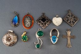 A collection of ten silver pendants of variable designs to include gem set and plain.