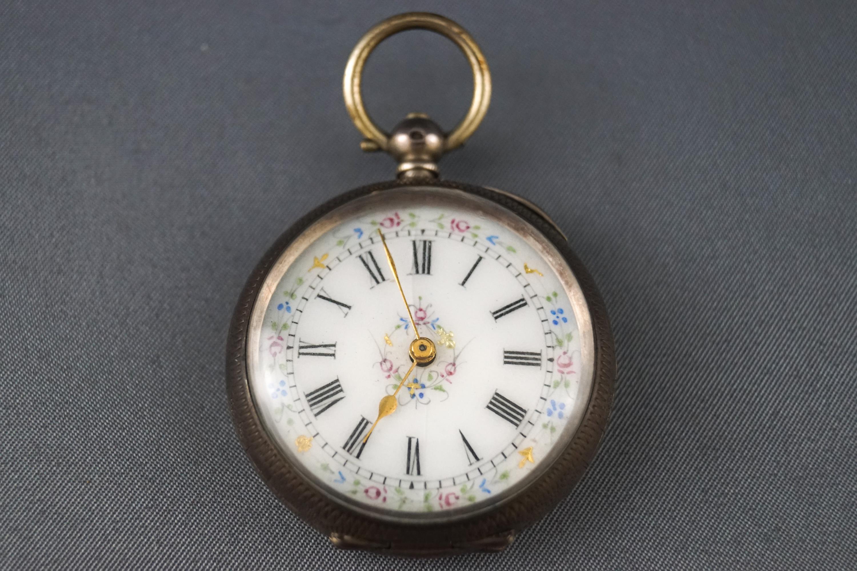 An 800 grade white metal open faced pocket watch with white ceramic floral design dial.