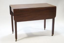 A 19th century Pembroke table on reeded square tapering legs with brass casters,
