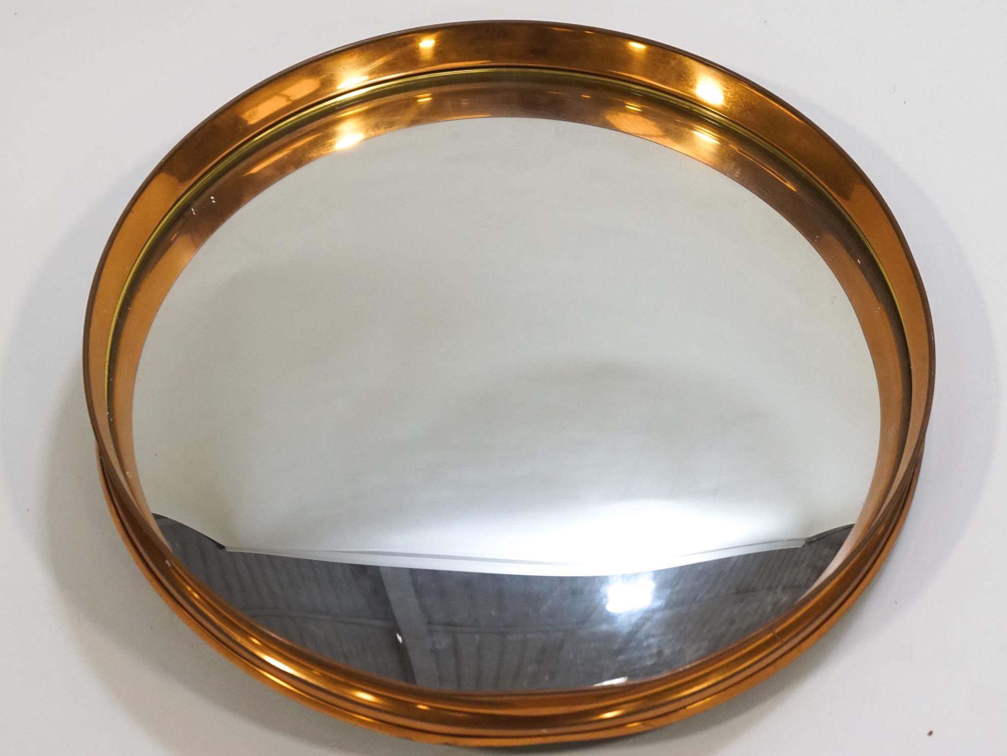 A copper framed convex mirror,