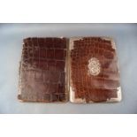 A crocodile skin and base metal wallet with applied silver mounts and monogram London 1898,