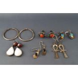 A collection of six pairs of silver earrings of variable designs.